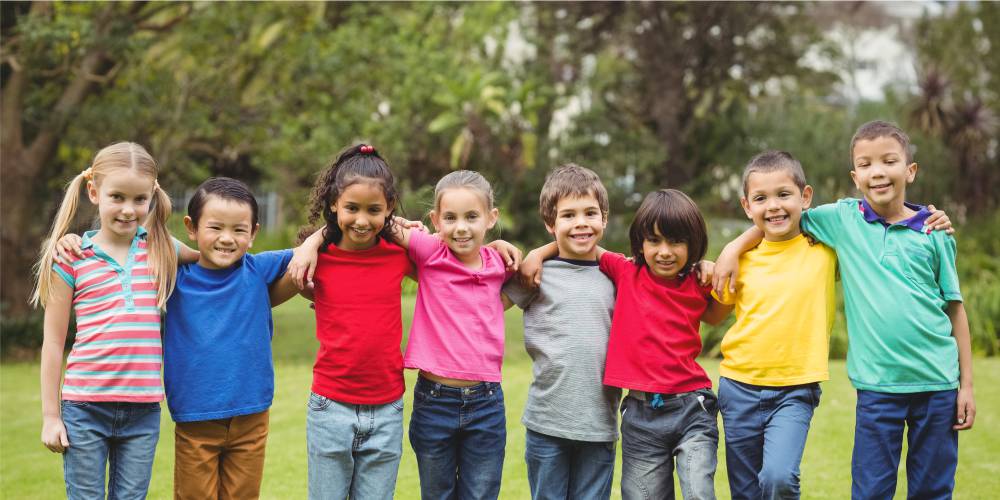 Fotografía de niños y niñas abrazados y sonrientes.