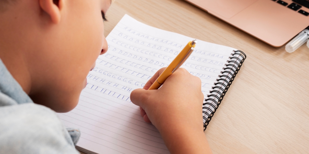 Fotografía de un niño escribiendo en un cuaderno.